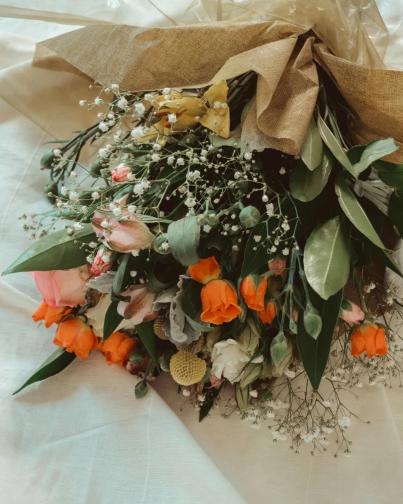 a bunch of flowers sitting on top of a bed, green and orange theme, wrapped in flowers, flatlay, commercially ready