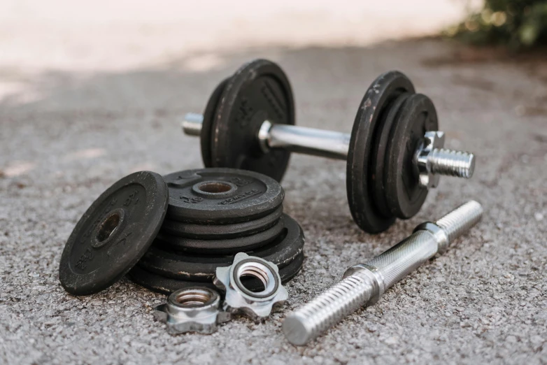 a couple of dumbs sitting on top of a cement ground, pexels contest winner, dau-al-set, lifting weights, knobs, spanners, stacked