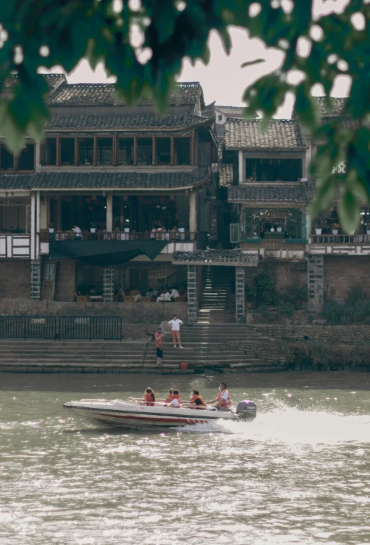 a group of people riding on top of a boat, by Reuben Tam, chinese building, near a river, full frame image, tudor