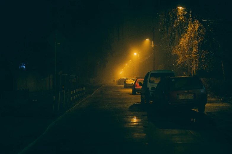 a street at night with cars parked on the side of the road, a picture, pexels contest winner, yellow mist, scary, dirty streets, an ominous haze