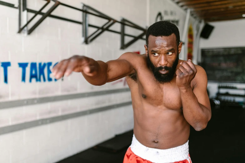 a man with a beard standing in a gym, sparring, riyahd cassiem, square, upper body image