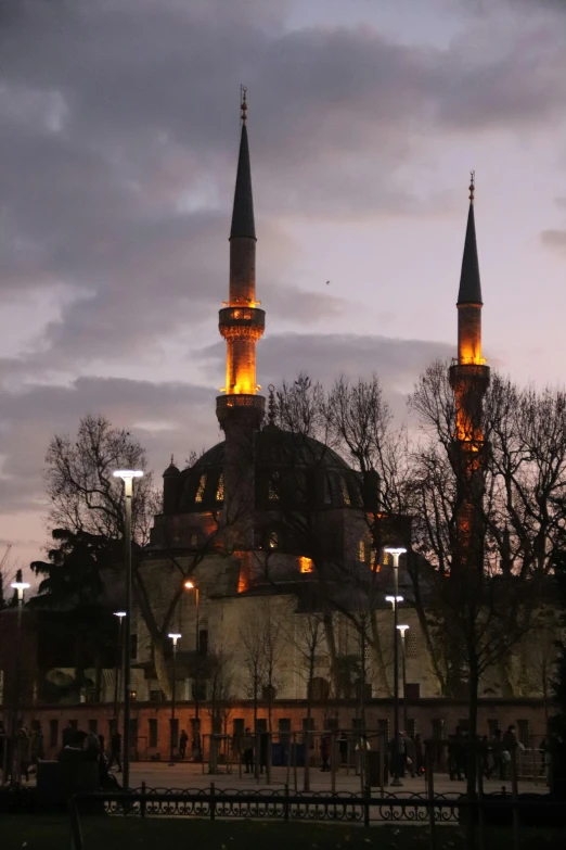 a view of a mosque lit up at night, an album cover, inspired by Altoon Sultan, hurufiyya, overcast dusk, two towers, taken in the late 2010s, parks and monuments