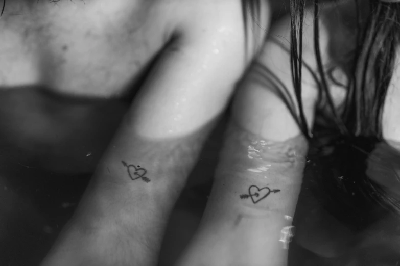 a close up of a person with a tattoo on their arm, a tattoo, by Emma Andijewska, romantic couple, sunken, (heart), image