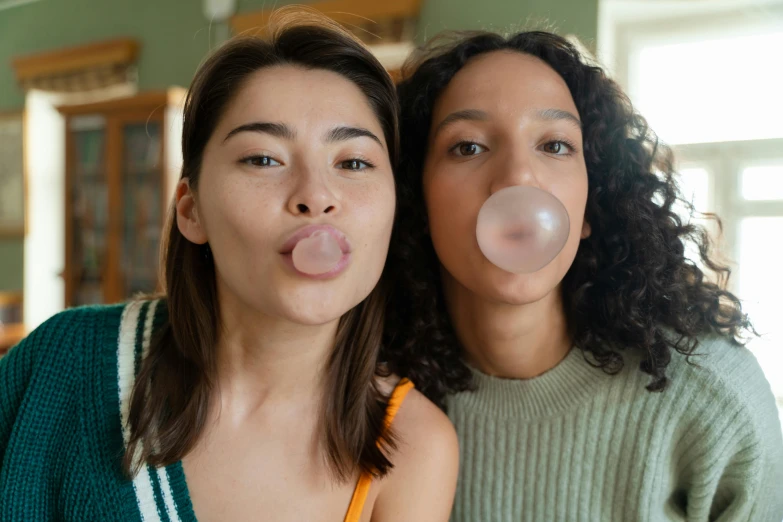 two women blowing bubbles while sitting at a table, trending on pexels, bubblegum face, brown, 1x, large lips