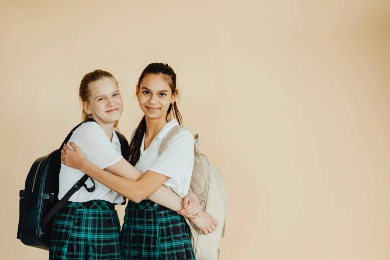 a couple of girls standing next to each other, pexels contest winner, danube school, plain background, avatar image, private school, promotional image