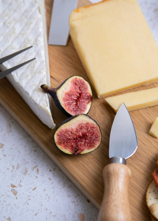 a cutting board topped with lots of different types of cheese, inspired by Peter de Sève, renaissance, 3 - piece, fig leaves, cutlery, up close