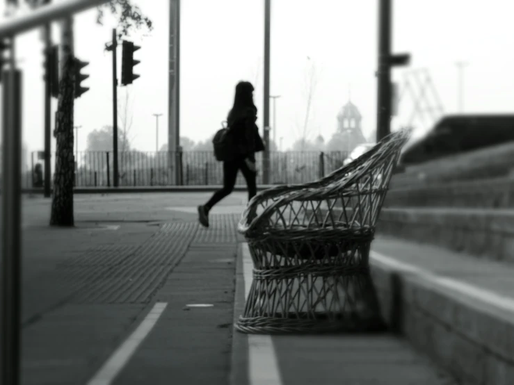 a black and white photo of a woman walking down a sidewalk, pexels contest winner, curved furniture, in the early morning, public art, lone girl waiting for the train