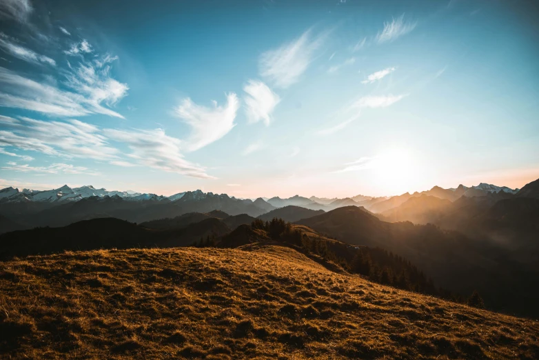 a person standing on top of a grass covered hill, by Sebastian Spreng, pexels contest winner, beautiful late afternoon, mountain ranges, perfect crisp sunlight, youtube thumbnail