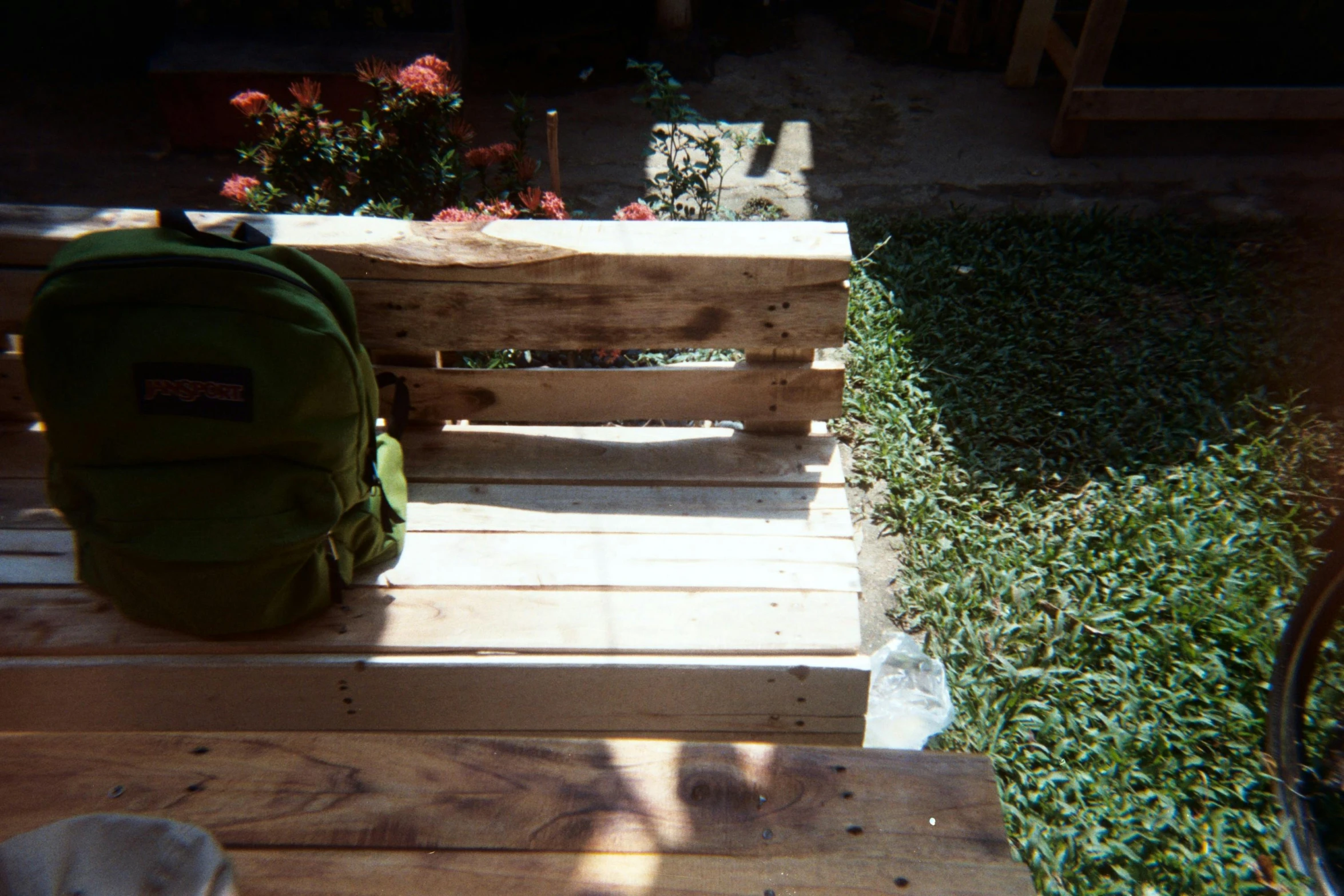 a backpack sitting on top of a wooden bench, by Pablo Rey, process art, pallet, garden at home, steps leading down, in marijuanas gardens