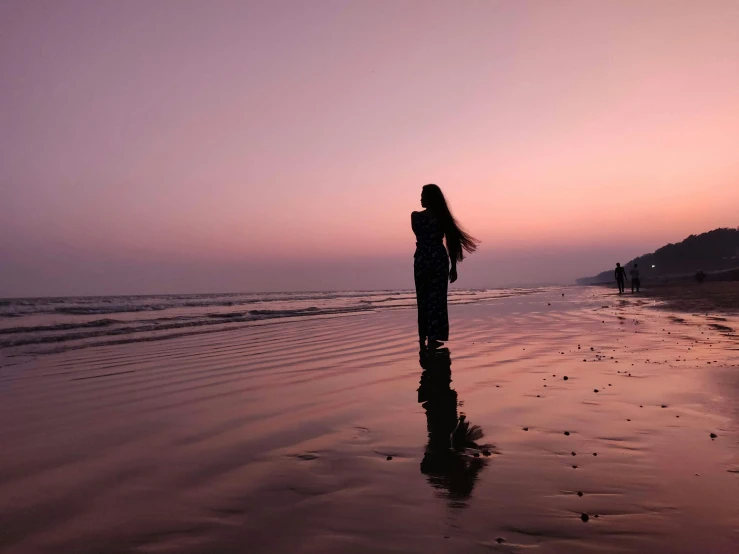 a woman standing on top of a beach next to the ocean, by Maggie Hamilton, pexels contest winner, romanticism, guwahati, pink hues, reflecting, profile image