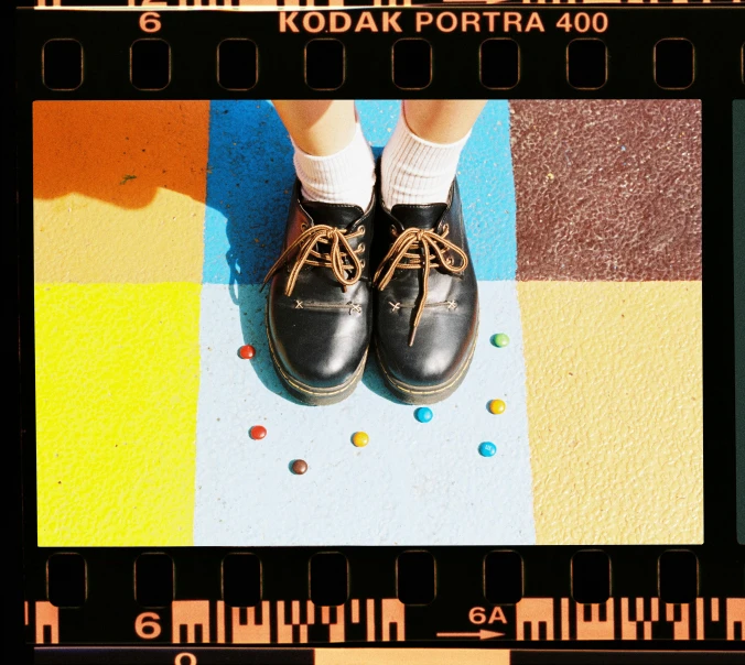 a close up of a person wearing black shoes, a polaroid photo, instagram, photorealism, technicolour film, polkadots, professional kodak lenses, ad image