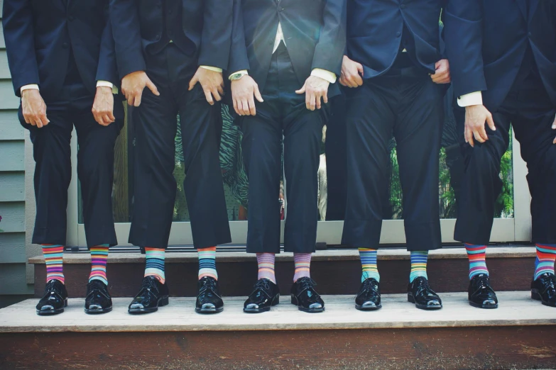 a group of men standing next to each other wearing colorful socks, pexels, renaissance, black tie, bumps, groom, colourised