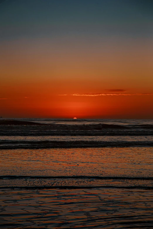 the sun is setting over the water at the beach, by Andries Stock, today\'s featured photograph 4k, goodnight, glossy surface, orange