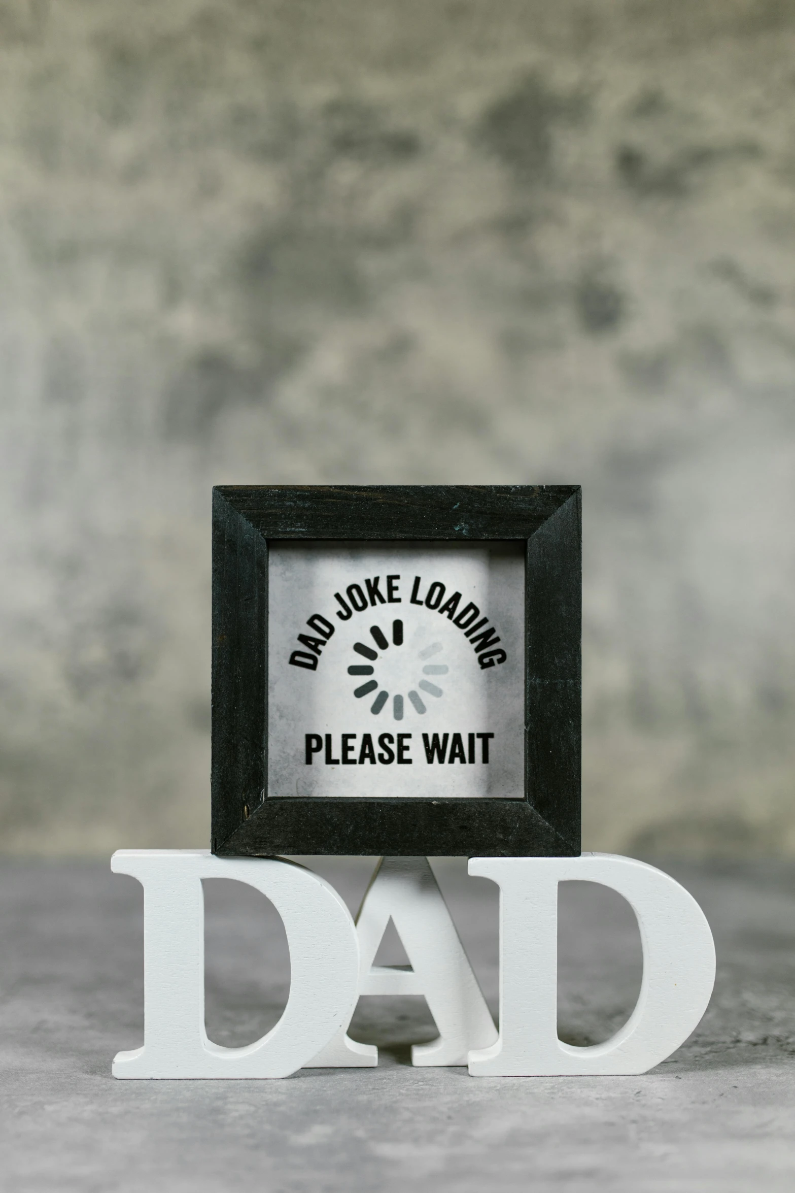 a picture frame sitting on top of a table next to a clock, by Paul Bird, dau-al-set, i'm dad, on grey background, warning, made of all white ceramic tiles