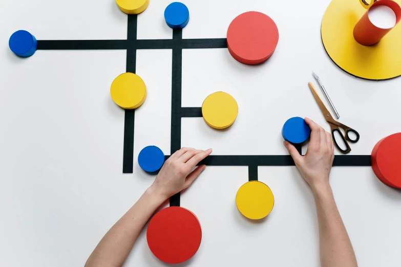 a person cutting circles with a pair of scissors, an abstract sculpture, inspired by Mondrian, trending on unsplash, de stijl, whiteboards, magnetic, made of dots, eero aarnio