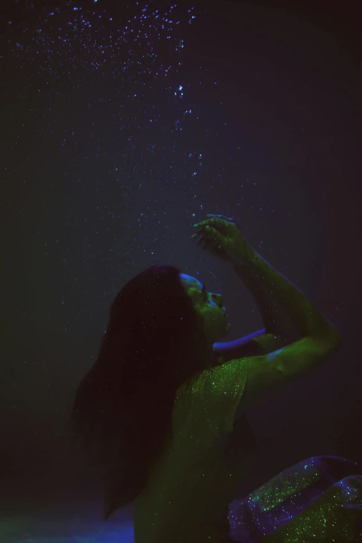 a woman sitting on top of a bed under a green light, inspired by Elsa Bleda, unsplash, conceptual art, underwater bubbles, deep dark purple waters, looking up at the stars, in water up to her shoulders