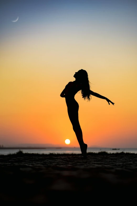 a woman standing on top of a beach next to the ocean, by Julian Allen, pexels contest winner, arabesque, classic dancer striking a pose, ((sunset)), beautiful female body silhouette, today\'s featured photograph 4k