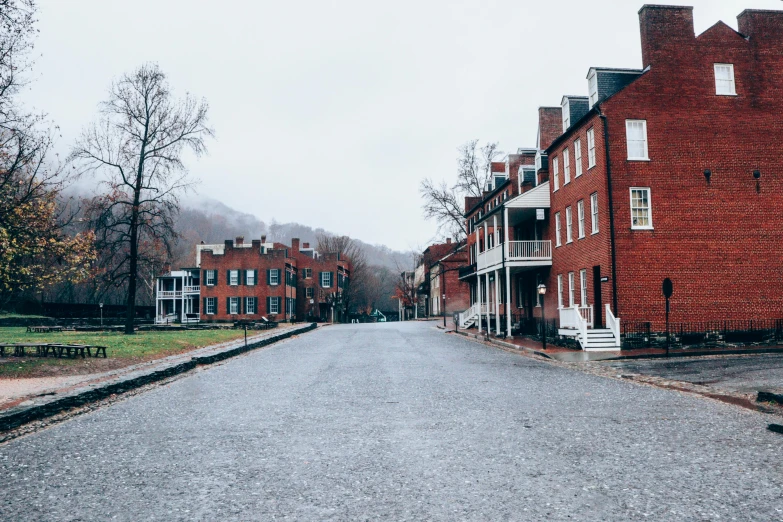 a red brick building sitting on the side of a road, by Carey Morris, pexels contest winner, white houses, colonial exploration, background image, brandywine school