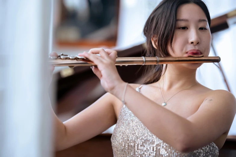 a woman in a silver dress playing a flute, unsplash, a young asian woman, thumbnail, sydney hanson, qichao wang