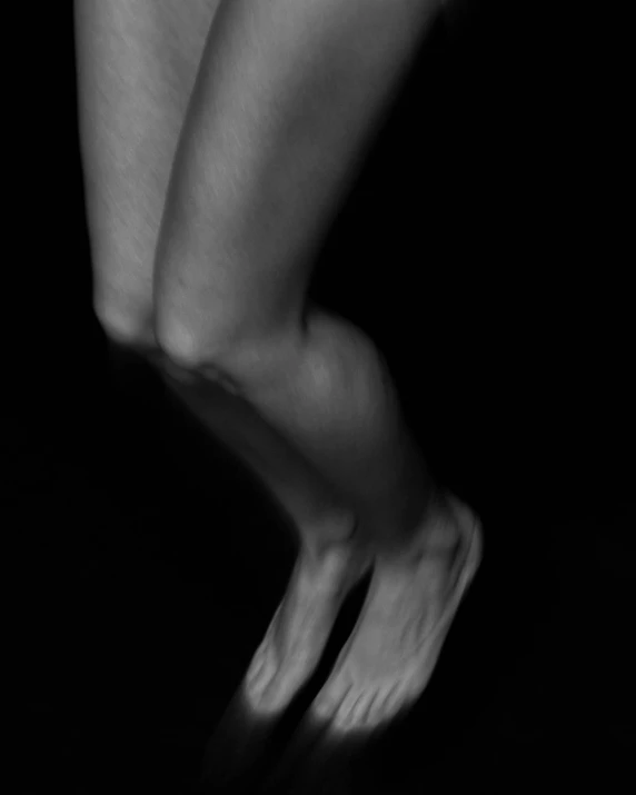 a black and white photo of a woman's legs, a black and white photo, inspired by Robert Mapplethorpe, captures emotion and movement, mid night, jumping at the viewer, mesomorph