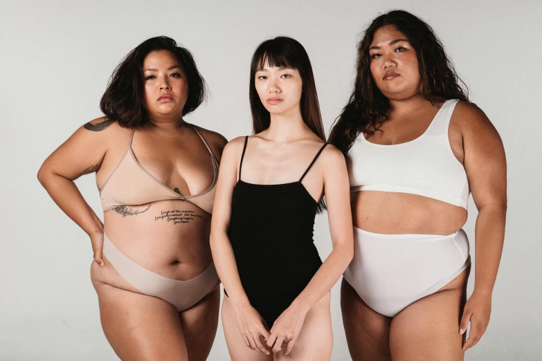 a group of three women standing next to each other, inspired by Vanessa Beecroft, trending on pexels, attire: bikini, half asian, beautiful thick female, bloated