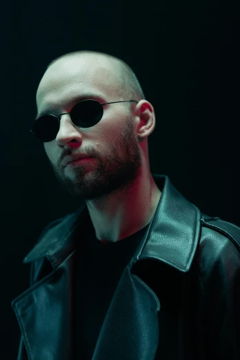 a man in a leather jacket and sunglasses, unsplash, photorealism, no hair, dark. studio lighting, official music video, avatar image