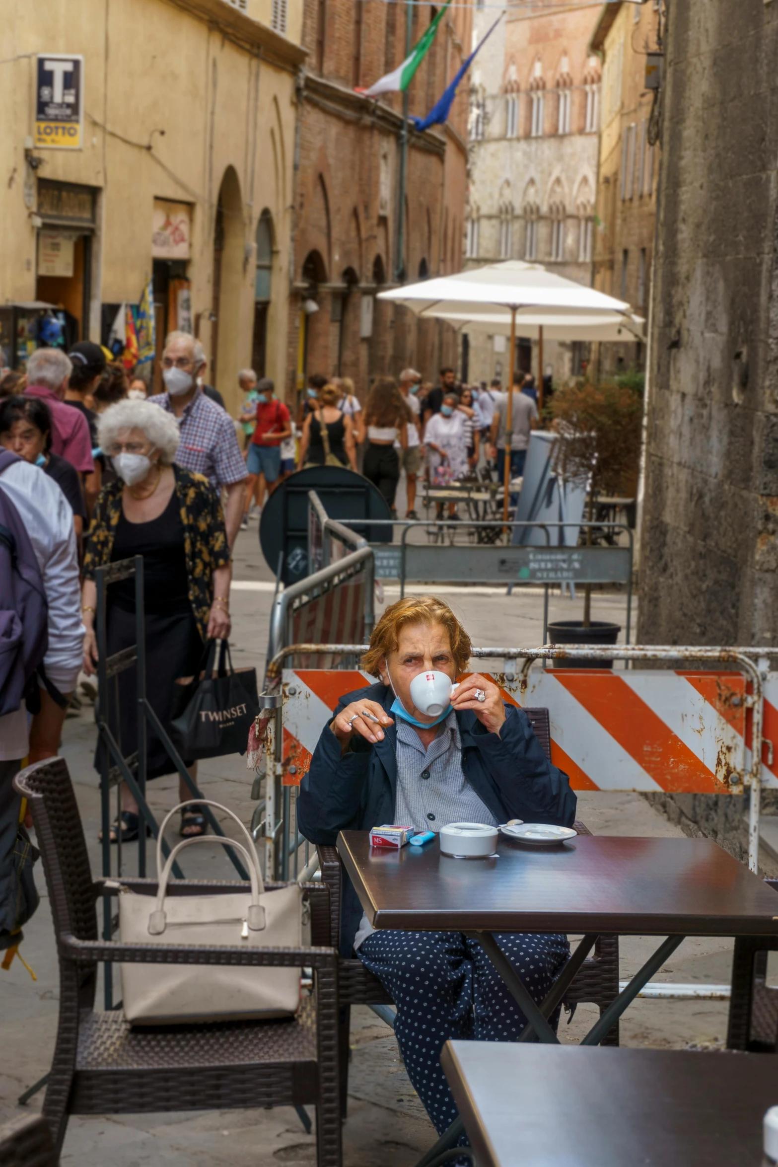 a man sitting at a table with a cup of coffee, by Bernie D’Andrea, pexels contest winner, renaissance, people are wearing masks, running through italian town, oc, square