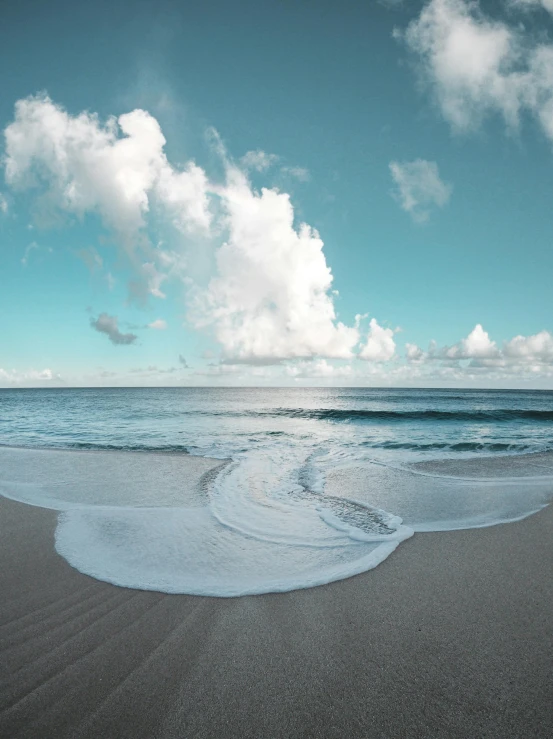 a large body of water sitting on top of a sandy beach, by Ryan Pancoast, clouds and wings and waves, light blue water, slide show, curvacious