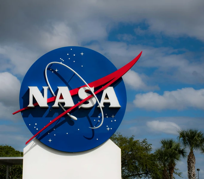 a nasa sign with palm trees in the background, unsplash, avatar image, instagram picture, low angle photo, group photo