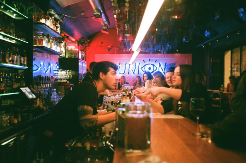 a group of people sitting at a bar, by Niko Henrichon, unsplash, underground comix, unholy union, neon standup bar, lurking, avalon