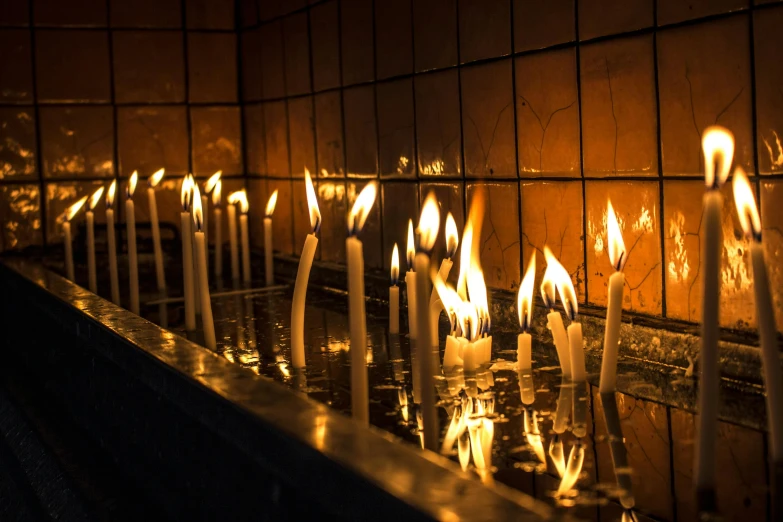 a row of lit candles in a dark room, inspired by Elsa Bleda, trending on unsplash, baroque, inside the tomb of jesus, beautiful sunny day, numerous fires, profile image