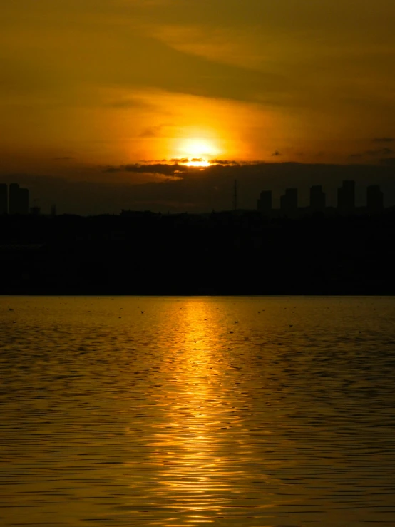 the sun is setting over a body of water, by Attila Meszlenyi, pexels contest winner, hurufiyya, manila, shades of gold display naturally, today\'s featured photograph 4k, blank