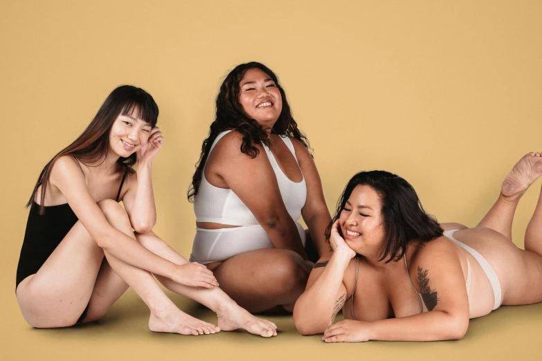 a group of women sitting next to each other, trending on pexels, figuration libre, strong fat bacchanalian body, asian descent, wearing nothing, her skin is light brown