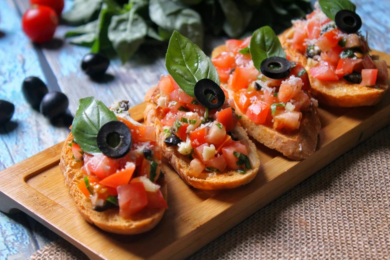 a wooden cutting board topped with slices of bread topped with tomatoes and olives, avatar image, basil, 1 petapixel image, square