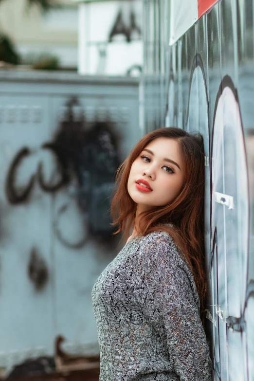 a woman leaning against a wall with graffiti on it, pexels contest winner, beautiful young asian woman, lipstick, grey, headshot photo