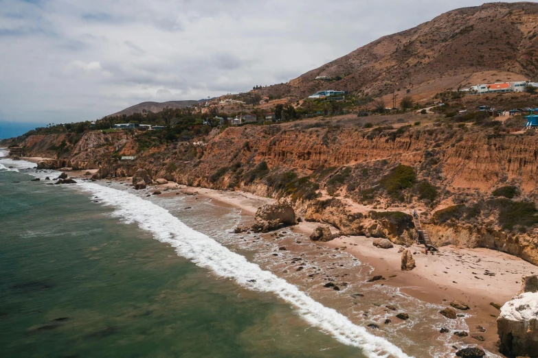 a large body of water next to a sandy beach, unsplash, renaissance, malibu canyon, “ aerial view of a mountain, realistic », conde nast traveler photo