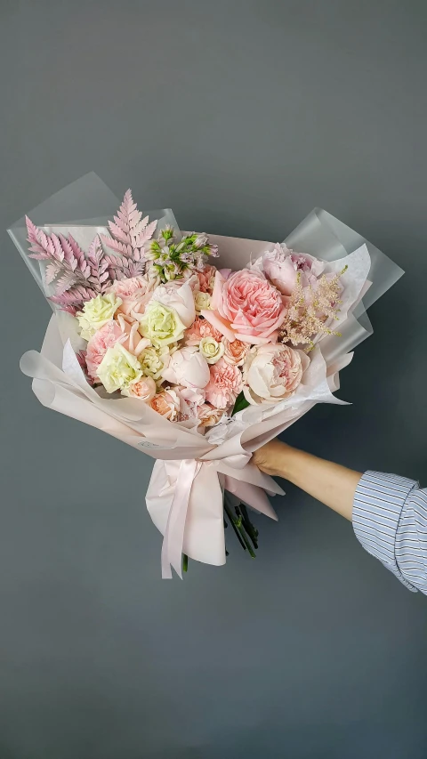 a person holding a bouquet of pink and white flowers, on a gray background, hey buddy, opalescent mist, large)}]