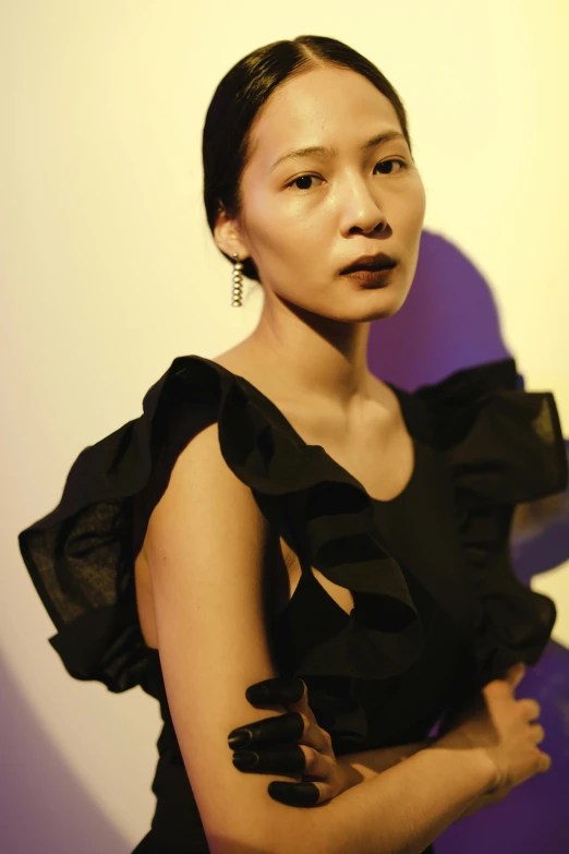 a woman in a black dress posing for a picture, inspired by Gao Xiang, looking away from the camera, frill, taken in the late 2010s, wearing a designer top