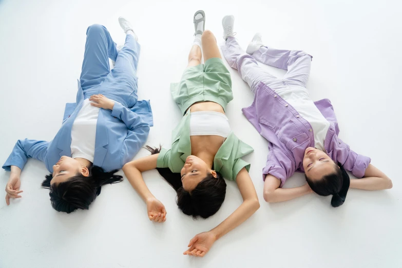 a group of people laying on top of each other, inspired by Ren Hang, trending on pexels, gutai group, nurse scrubs, three women, pastel clothing, three-dimensional