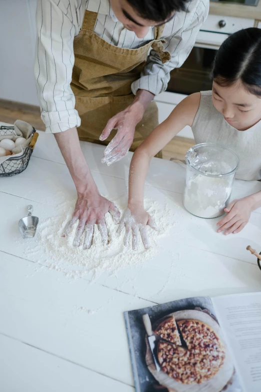 a man and a little girl making pizzas on a table, by Zeen Chin, pexels contest winner, process art, white clay, japanese, recipe, ignant