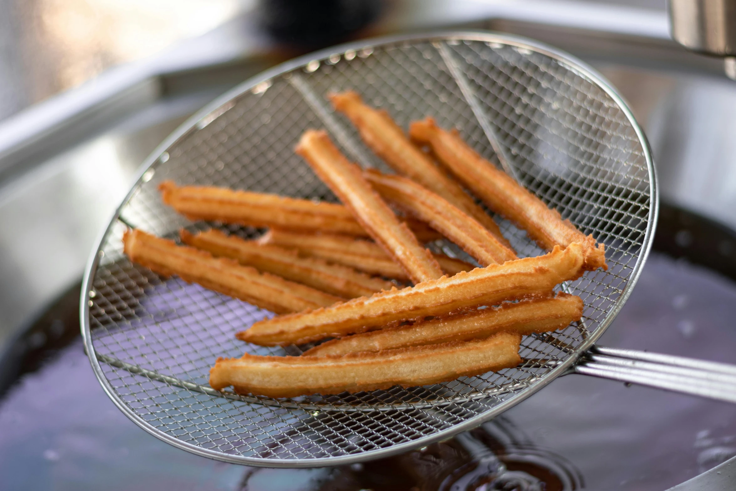 a basket filled with churros sitting on top of a stove, crisps, thin antennae, middle close up, square