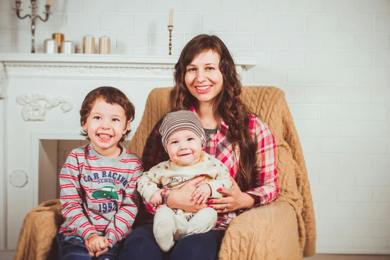 a woman sitting in a chair with two children, pexels contest winner, hurufiyya, avatar image, anna nikonova aka newmilky, high quality product image”, group photo