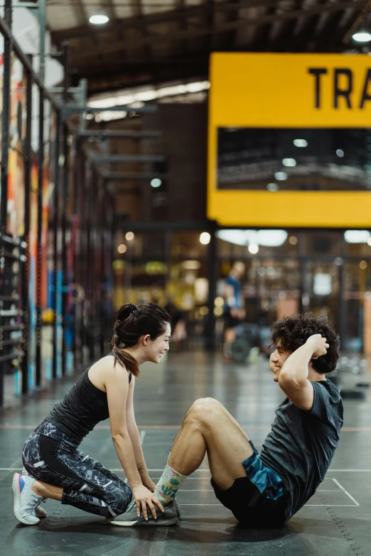 a couple of people that are sitting on the ground, in a gym, on a yellow canva, melbourne, thumbnail