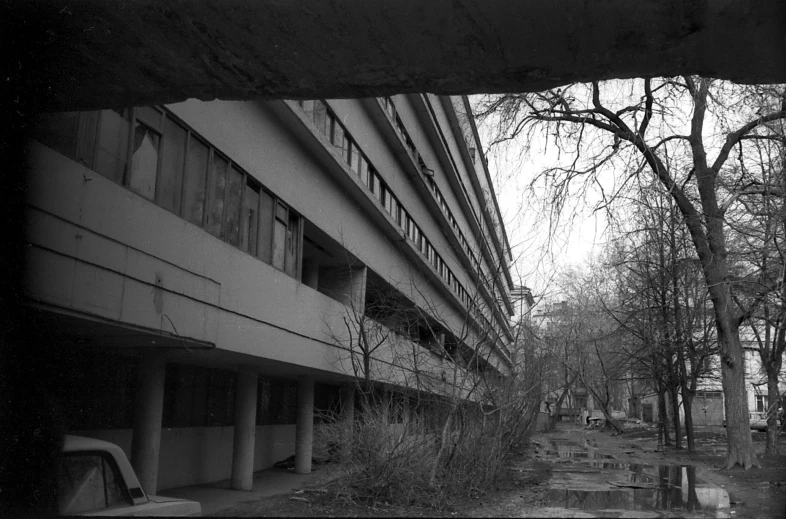 a black and white photo of an abandoned building, by Ihor Podolchak, flickr, brutalism, tall terrace, 000 — википедия, view from ground level, konica minolta