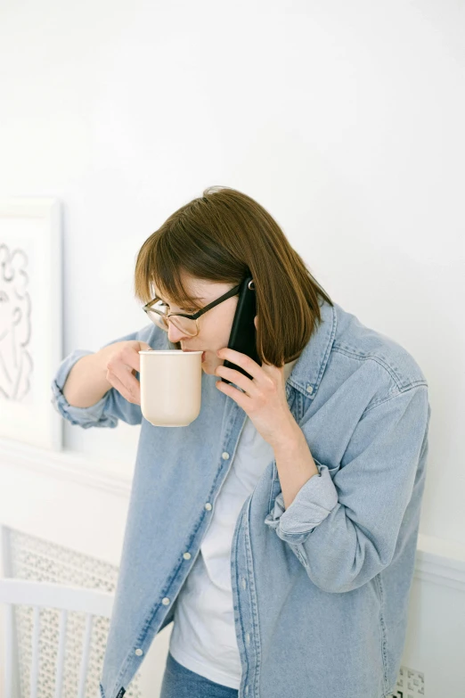 a woman talking on a cell phone while holding a cup of coffee, inspired by Sarah Lucas, happening, wearing a linen shirt, beige mist, japanese collection product, glasses |