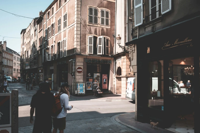 a group of people walking down a street next to tall buildings, a photo, by Raphaël Collin, pexels contest winner, renaissance, large windows to french town, stood outside a corner shop, taupe, summer light