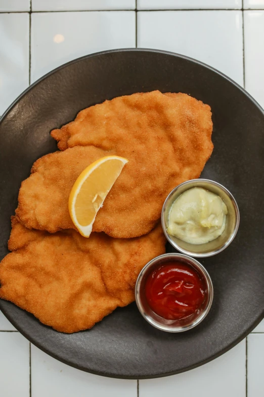 a close up of a plate of food with condiments, battered, 3 - piece, lemon, eastern european