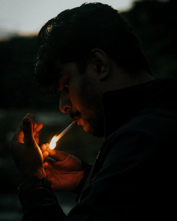 a man lighting a cigarette in the dark, an album cover, inspired by Elsa Bleda, pexels contest winner, sumatraism, profile image, ☁🌪🌙👩🏾, ganja, lgbtq
