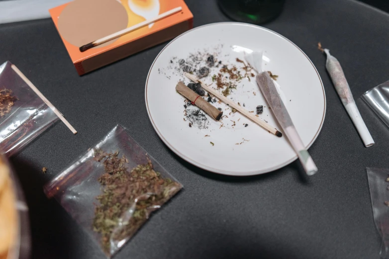 a white plate sitting on top of a table, a still life, inspired by Elsa Bleda, process art, pounds of weed, blunt borders, stick and poke, being mixed