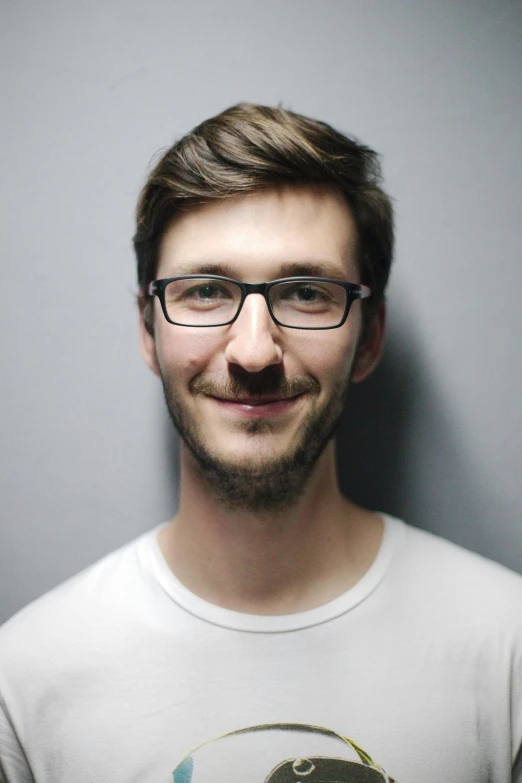 a man with glasses standing in front of a gray wall, reddit, mark edward fischbach, andrea savchenko, portait image, high resolution photo